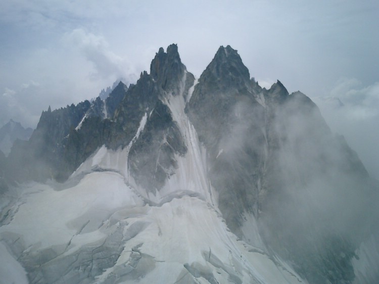 Aiguilles Blatiere till hälften dold i moln. Bilden är tagen från toppen av Grand Charmoz.     Foto: Andreas Bengtsson